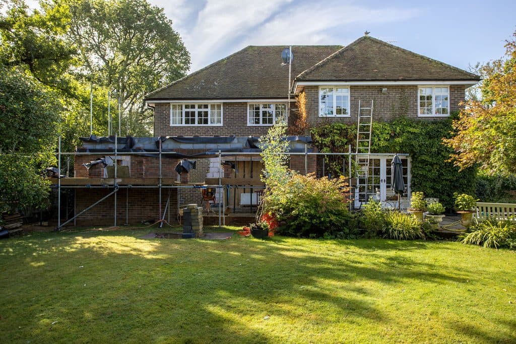 The same Guildford house during construction, the new single-storey extension standing under scaffolding.